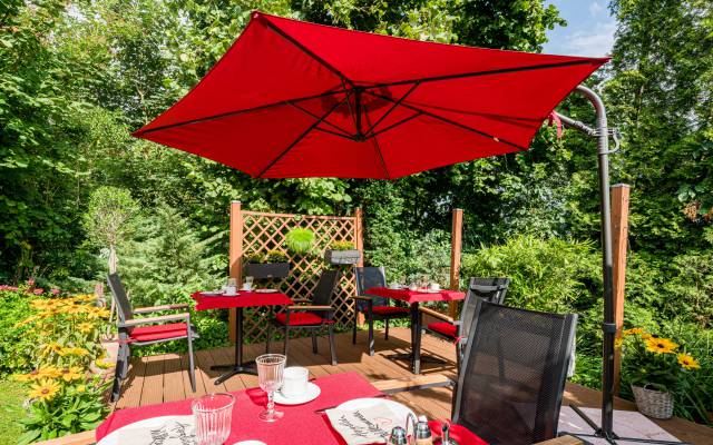 Gedeckte Frühstückstische im Garten, Hotel Haus Nussbaum in Ratingen